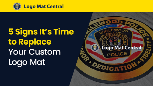 Worn custom logo mat with faded branding and curled edges in commercial entryway showing signs it needs replacement for safety and cleanliness